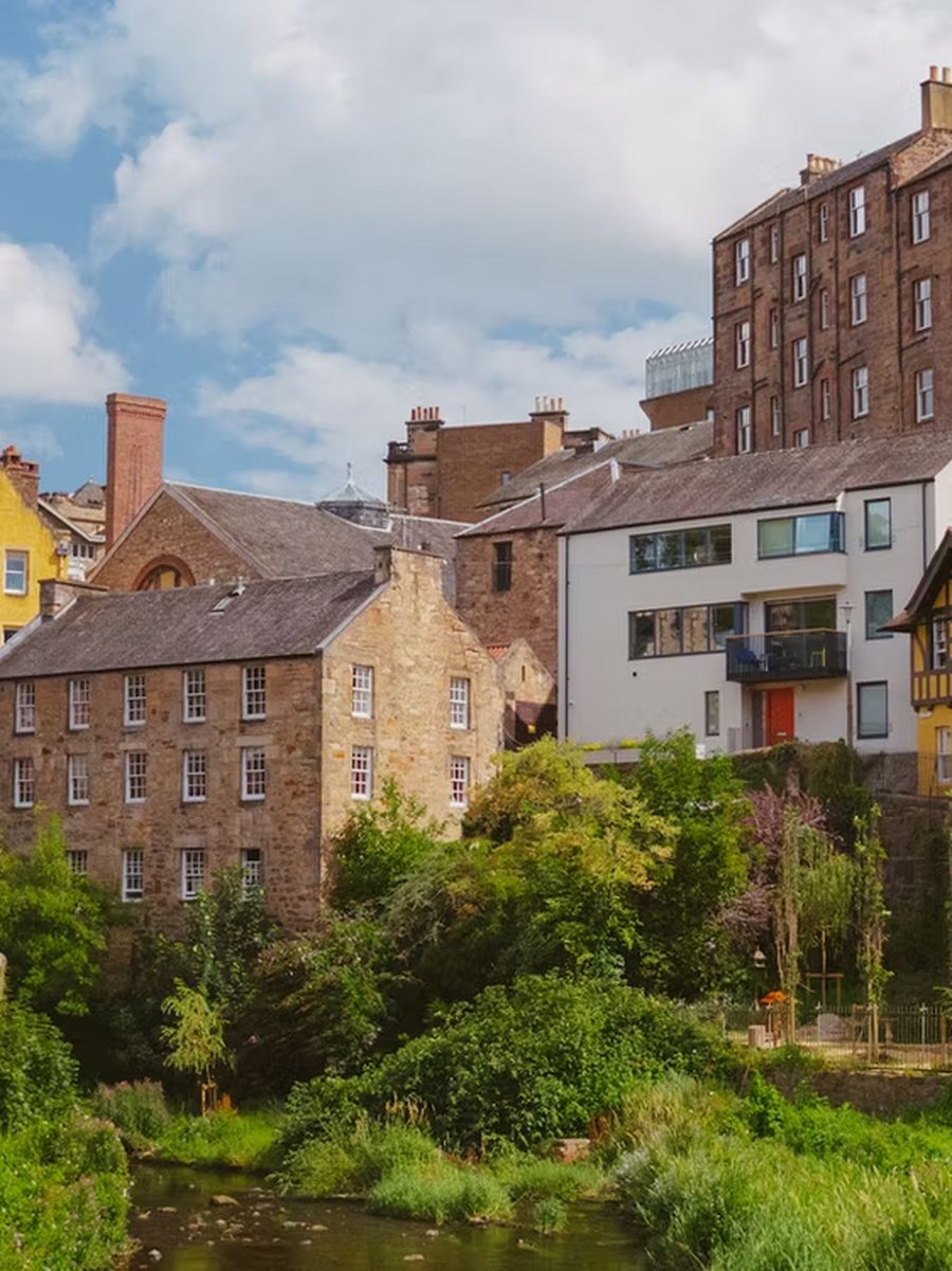 Dean Village in the sun: stone houses and the Water of Leith below the bridge.